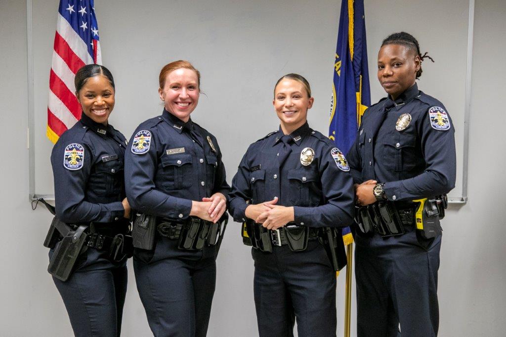 Four female officers standing in front of the American flag and the Kentucky state flag.