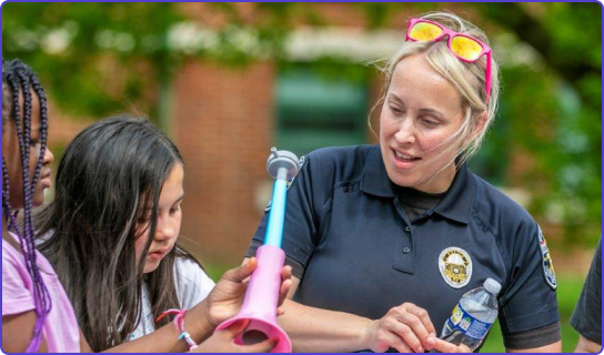 Woman police officer playing with a young girl outside